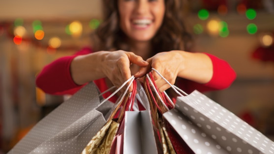woman with multiple holiday gift bags 