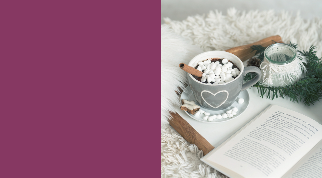 white furry rug with gray mug of hot cocoa with marshmallows and an open book